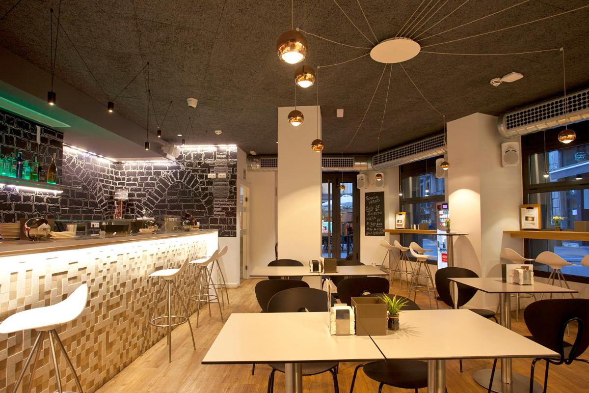 Un restaurante con mesas y sillas y un bar. en Hotel Pompaelo Plaza del Ayuntamiento & Spa, en Pamplona
