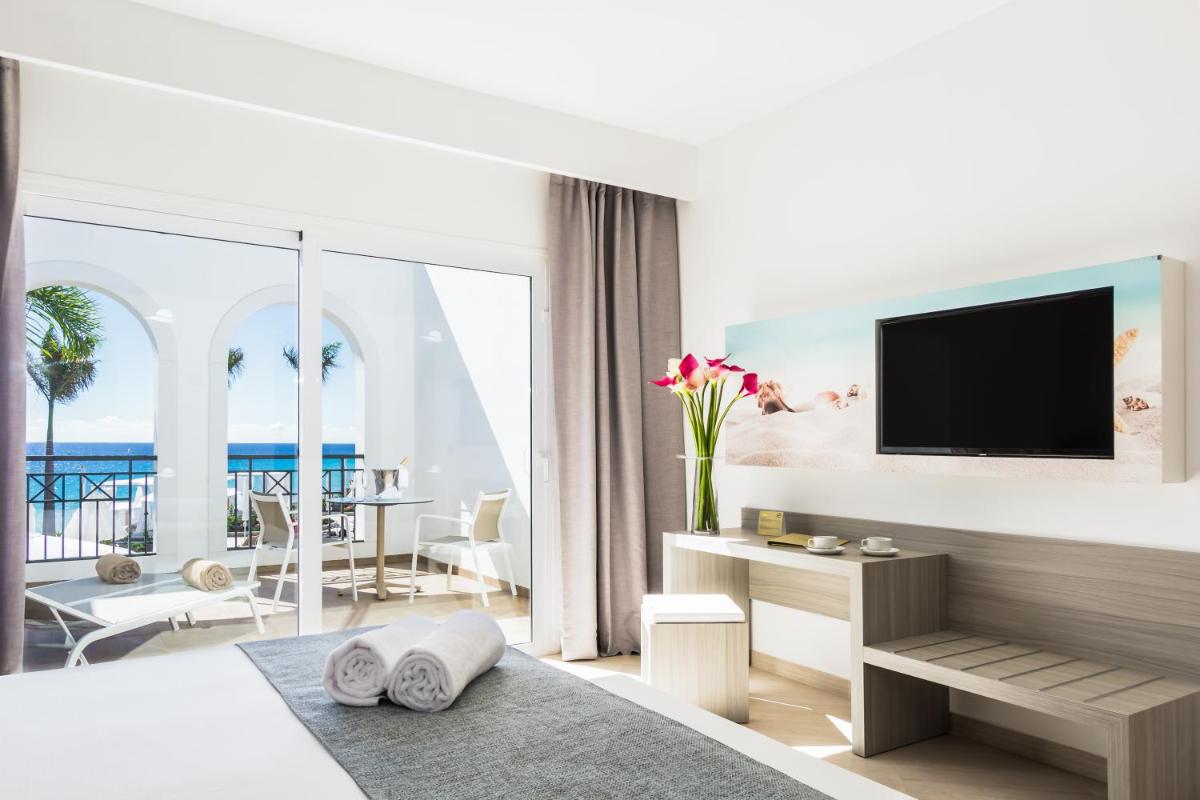 una habitación de hotel con una cama y un televisor en Royal Palm Resort & Spa - Adults Only, en Playa de Jandía