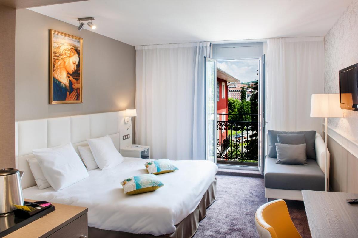 une chambre d'hôtel avec un lit et un balcon dans l'établissement Grand Hotel Gallia & Londres, à Lourdes