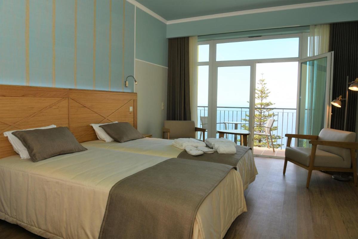 um quarto de hotel com uma cama grande e uma varanda em Hotel Do Campo em Ribeira Brava