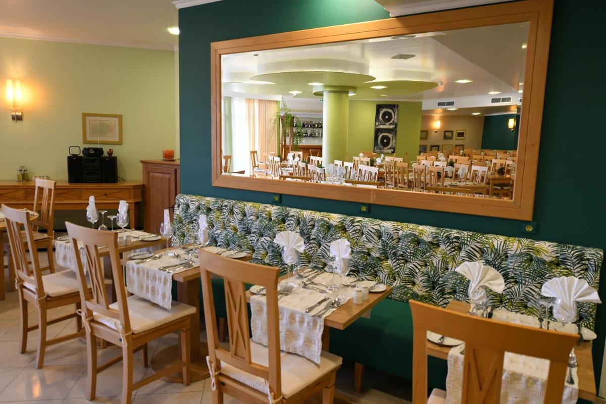 uma sala de jantar com mesas e um espelho grande em Hotel Do Campo em Ribeira Brava