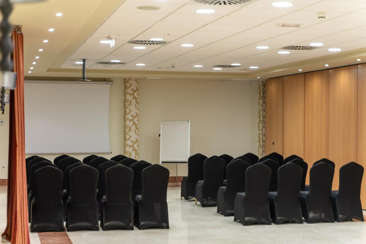 una sala de conferencias con sillas negras y una pantalla blanca en Hotel Sun Palace Albir & Spa, en Albir 45 fotos más