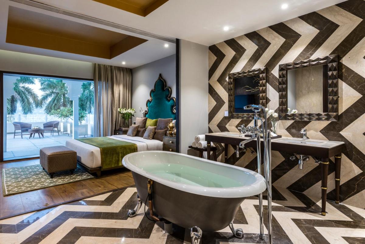 a bathroom with a tub and a bedroom at Hotel Lakend in Udaipur