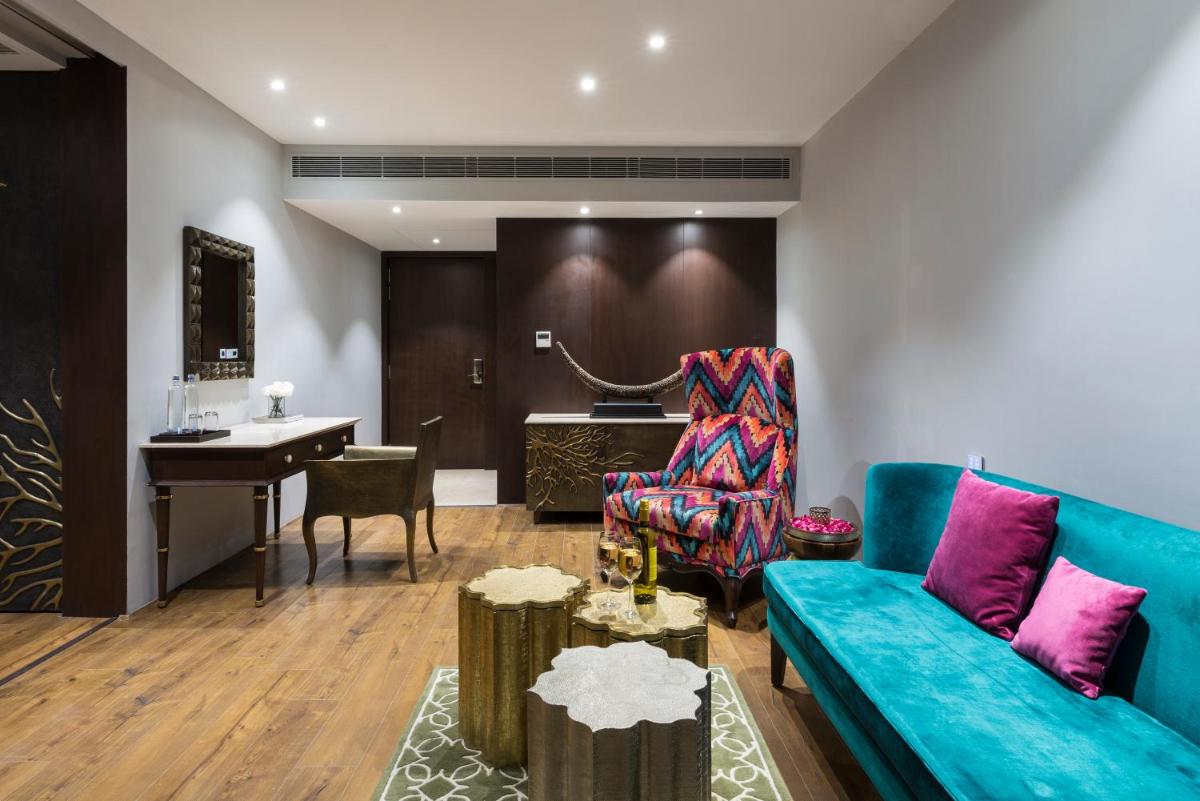 a living room with a blue couch and a piano at Hotel Lakend in Udaipur