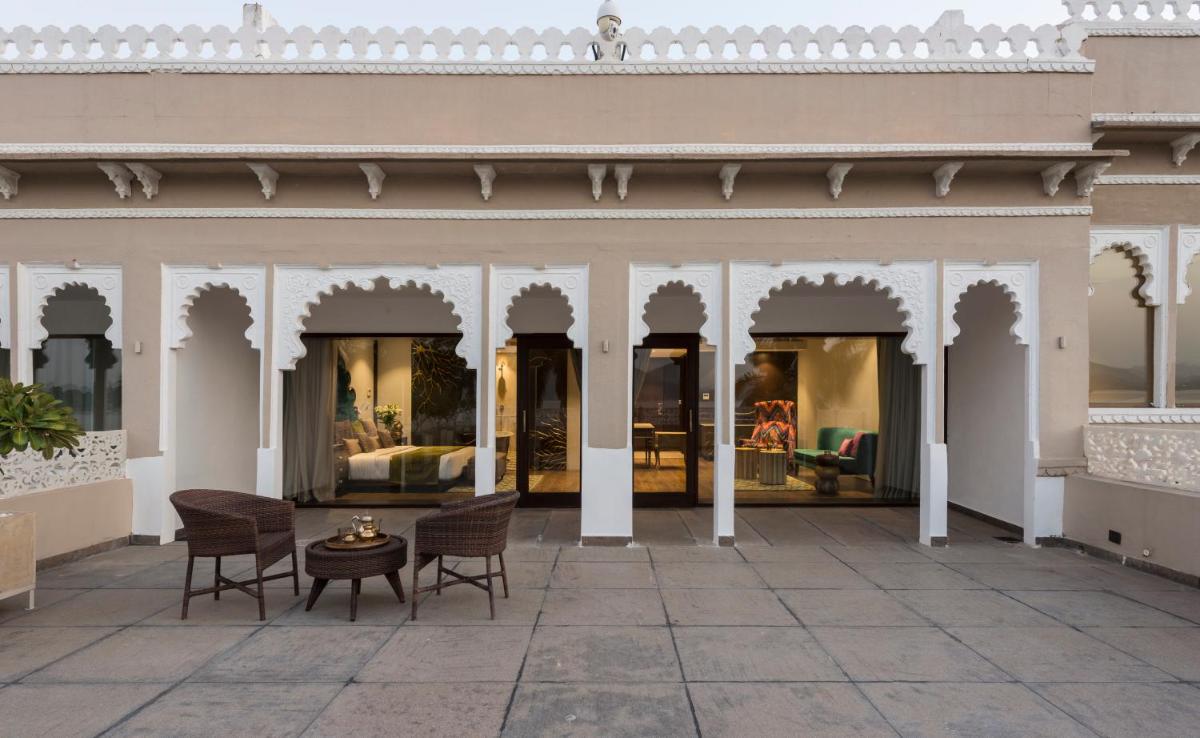 a courtyard of a building with chairs and tables at Hotel Lakend in Udaipur