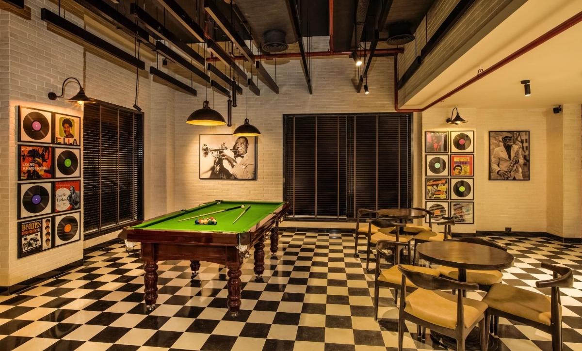 a room with a pool table and some chairs at Lemon Tree Premier City Center Pune in Pune