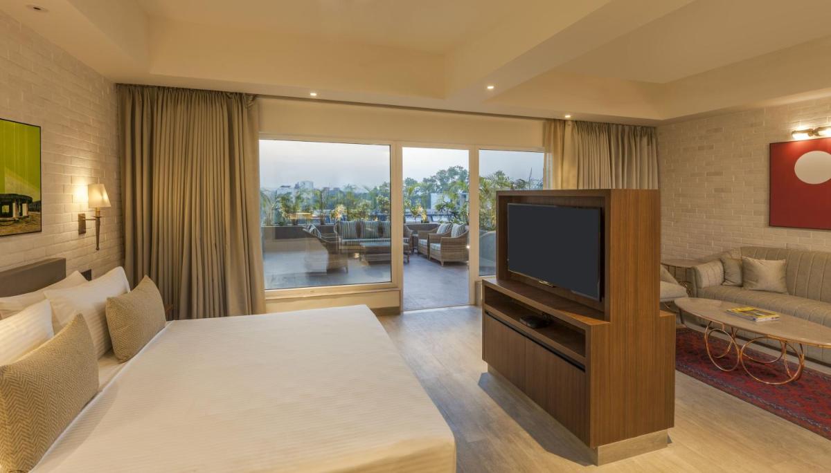 a living room with a television and a couch at Lemon Tree Premier City Center Pune in Pune +36 photos