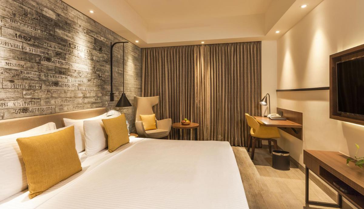 a hotel room with a bed and a desk at Lemon Tree Premier City Center Pune in Pune