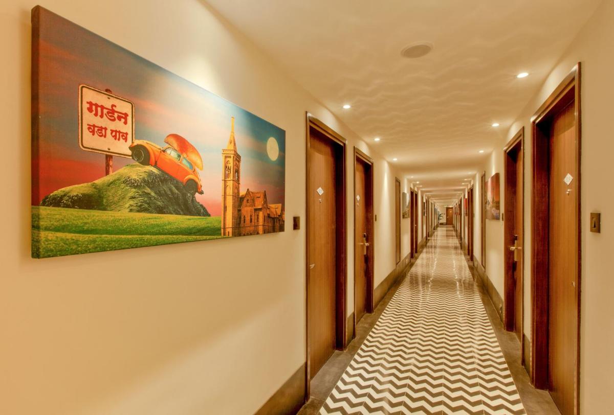 a corridor in a building with a painting on the wall at Lemon Tree Premier City Center Pune in Pune