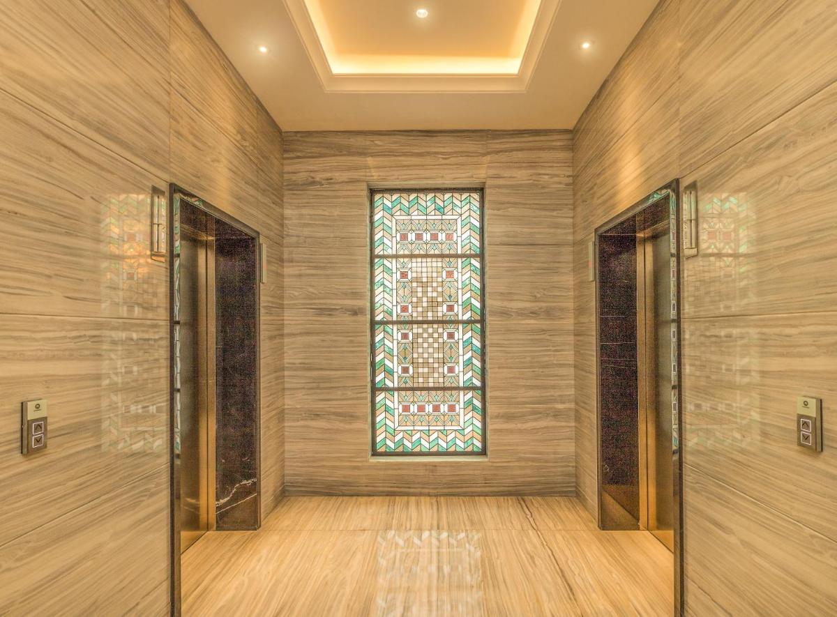 a hallway with two doors and a window at Lemon Tree Premier City Center Pune in Pune