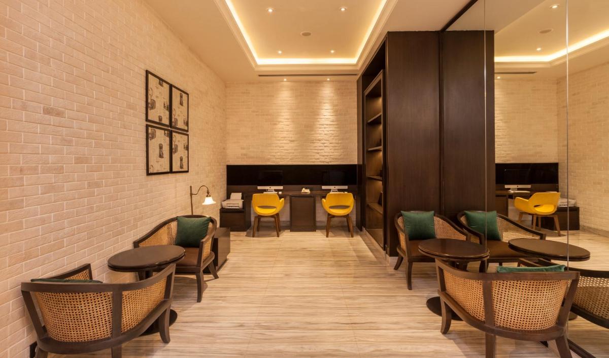a dining room with tables and yellow chairs at Lemon Tree Premier City Center Pune in Pune