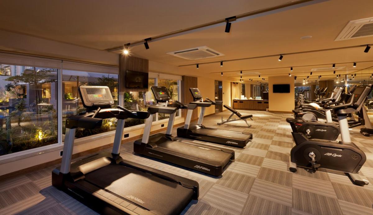 a gym with a bunch of treadmills in a room at Lemon Tree Premier City Center Pune in Pune