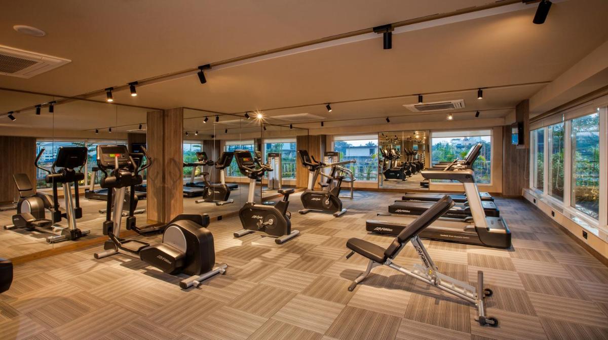 a gym with treadmills and elliptical machines at Lemon Tree Premier City Center Pune in Pune