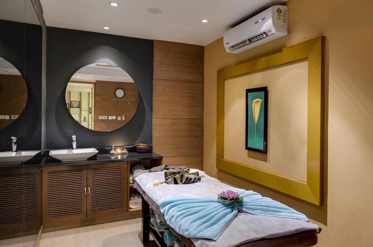 a bathroom with a bed and a sink at Pride Plaza Hotel, Kolkata in Kolkata