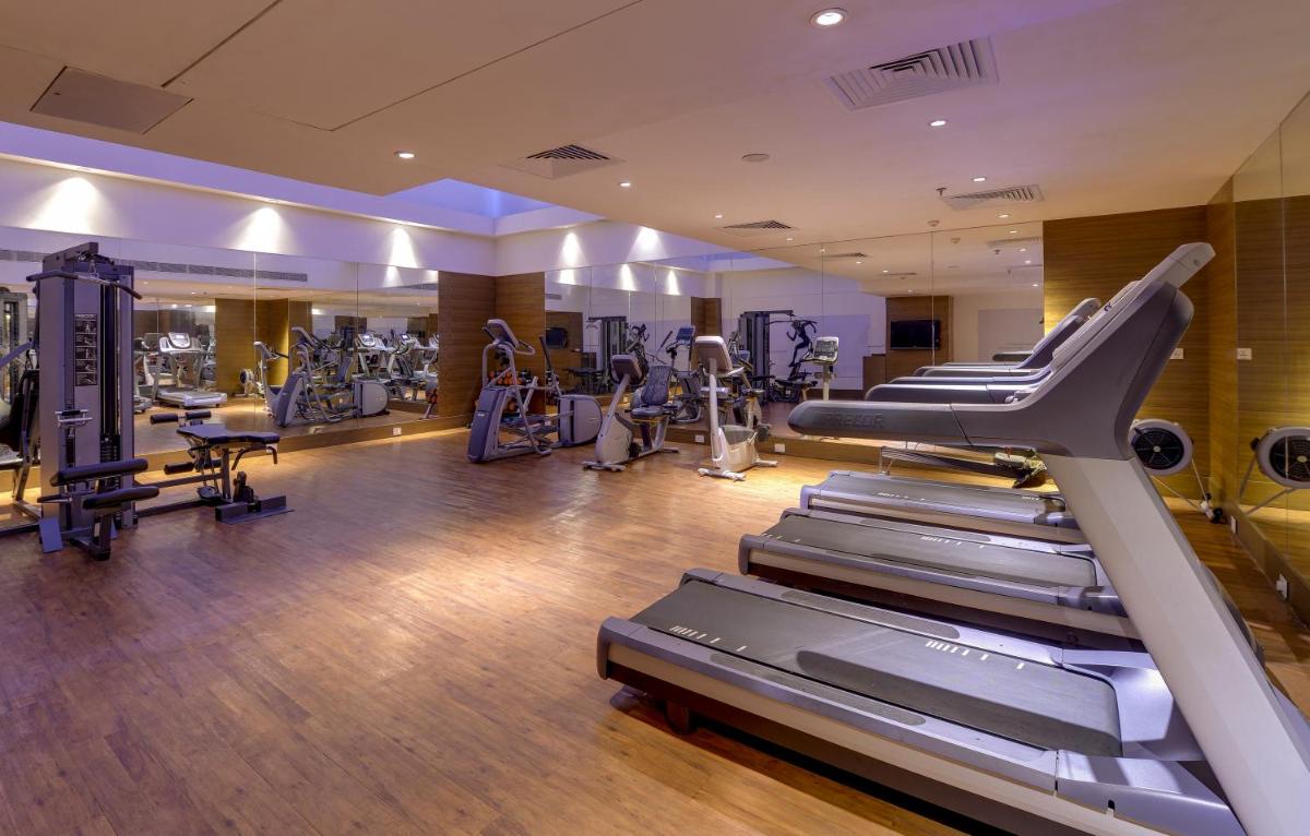 a gym with treadmills and machines in a room at Pride Plaza Hotel, Kolkata in Kolkata