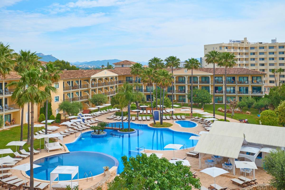 una vista aérea de un complejo con 2 piscinas y tumbonas en CM Mallorca Palace - Only Adults, en Sa Coma