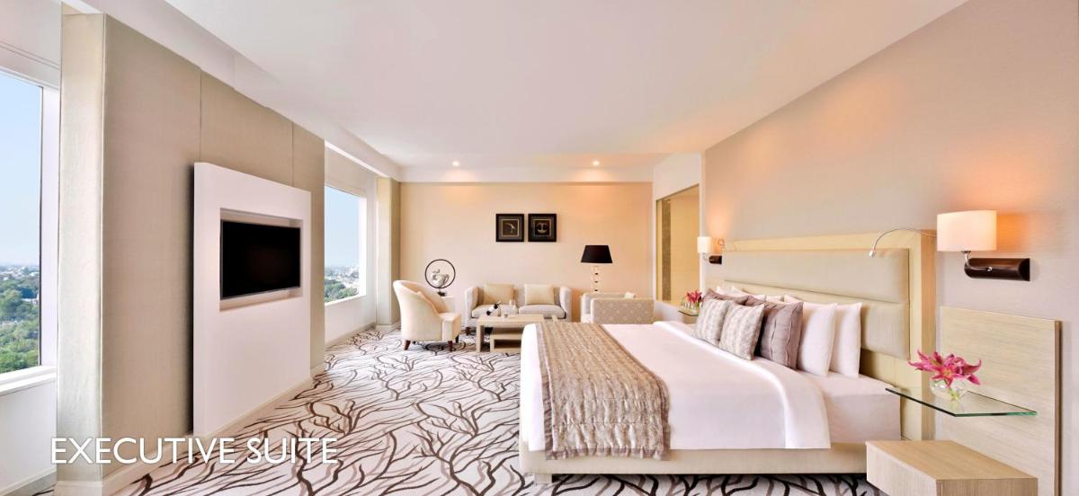 a hotel room with a bed and a living room at Radisson Blu Bengaluru Outer Ring Road in Bengaluru