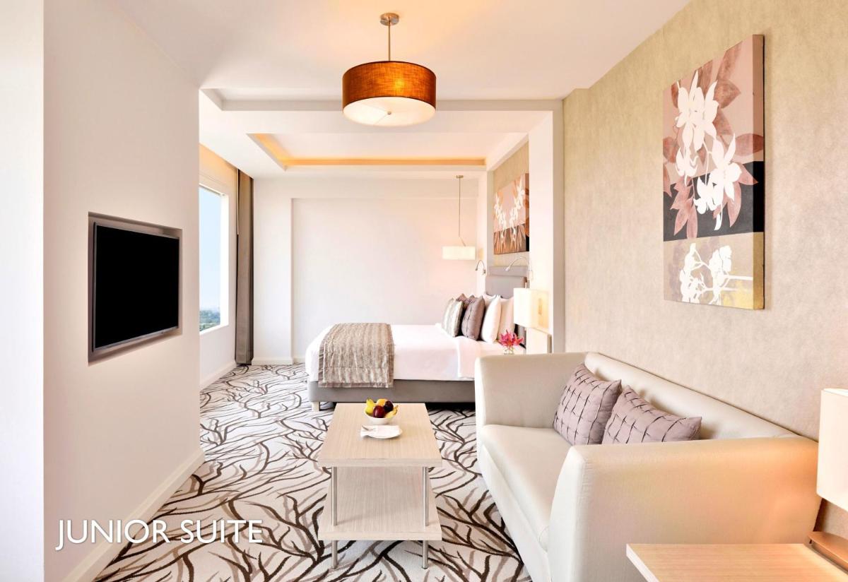 a living room with a couch and a bed at Radisson Blu Bengaluru Outer Ring Road in Bengaluru