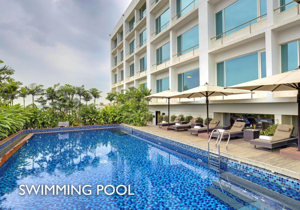 a swimming pool in front of a building at Radisson Blu Bengaluru Outer Ring Road in Bengaluru