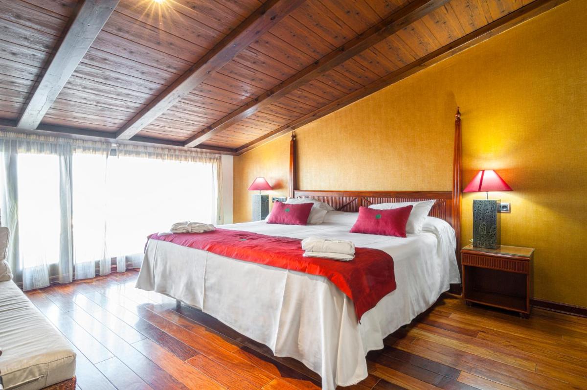 1 dormitorio grande con 1 cama grande con almohadas rojas en Hotel & Spa Sierra de Cazorla 4*, en Cazorla