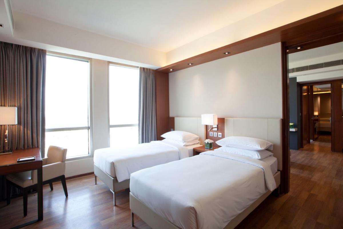 a hotel room with two beds and a desk at Hyatt Regency Amritsar Hotel & Spa in Amritsar