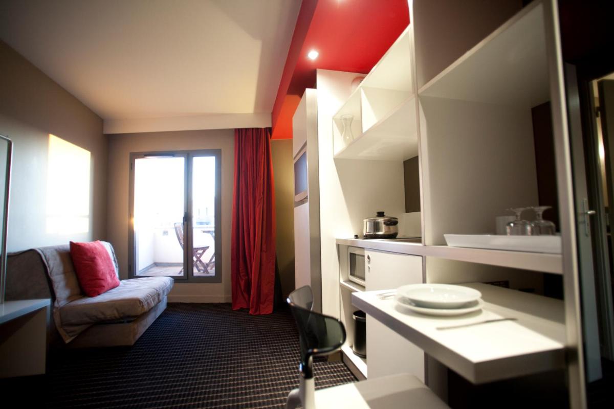 une pièce avec un canapé et une chaise dans une pièce dans l'établissement B&B HOME Lyon Centre Berthelot, à Lyon