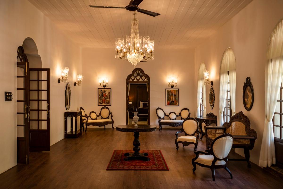 a living room with chairs and a chandelier at The Postcard Cuelim, Goa in Cansaulim