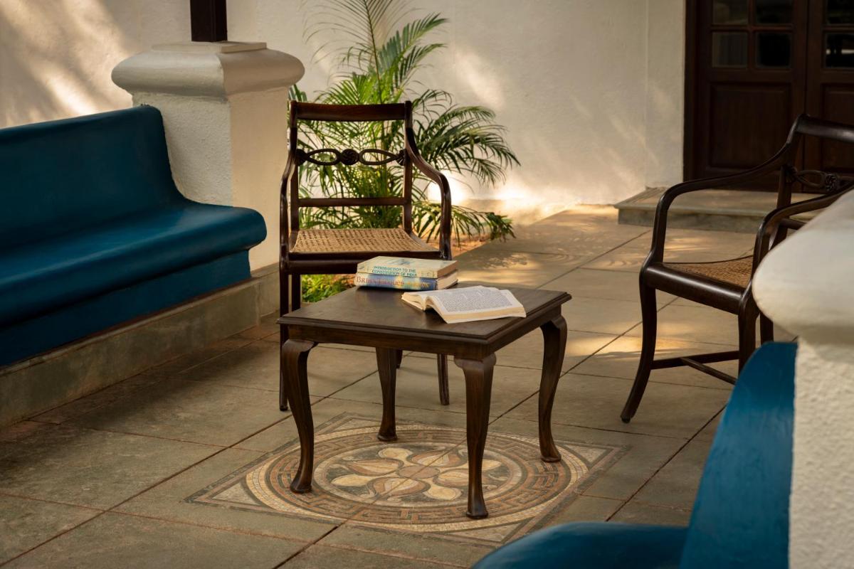 a wooden chair and a table in a room at The Postcard Cuelim, Goa in Cansaulim