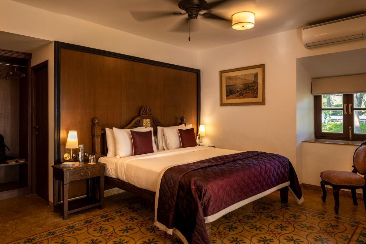 a hotel room with a bed and a chair at The Postcard Cuelim, Goa in Cansaulim