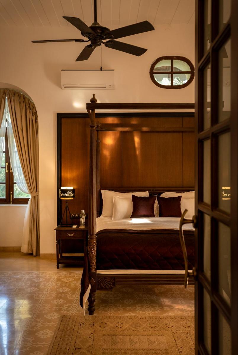 a bedroom with a bed with a ceiling fan at The Postcard Cuelim, Goa in Cansaulim