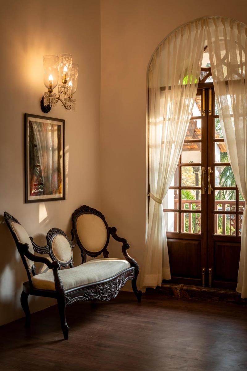 a room with a chair in front of a window at The Postcard Cuelim, Goa in Cansaulim