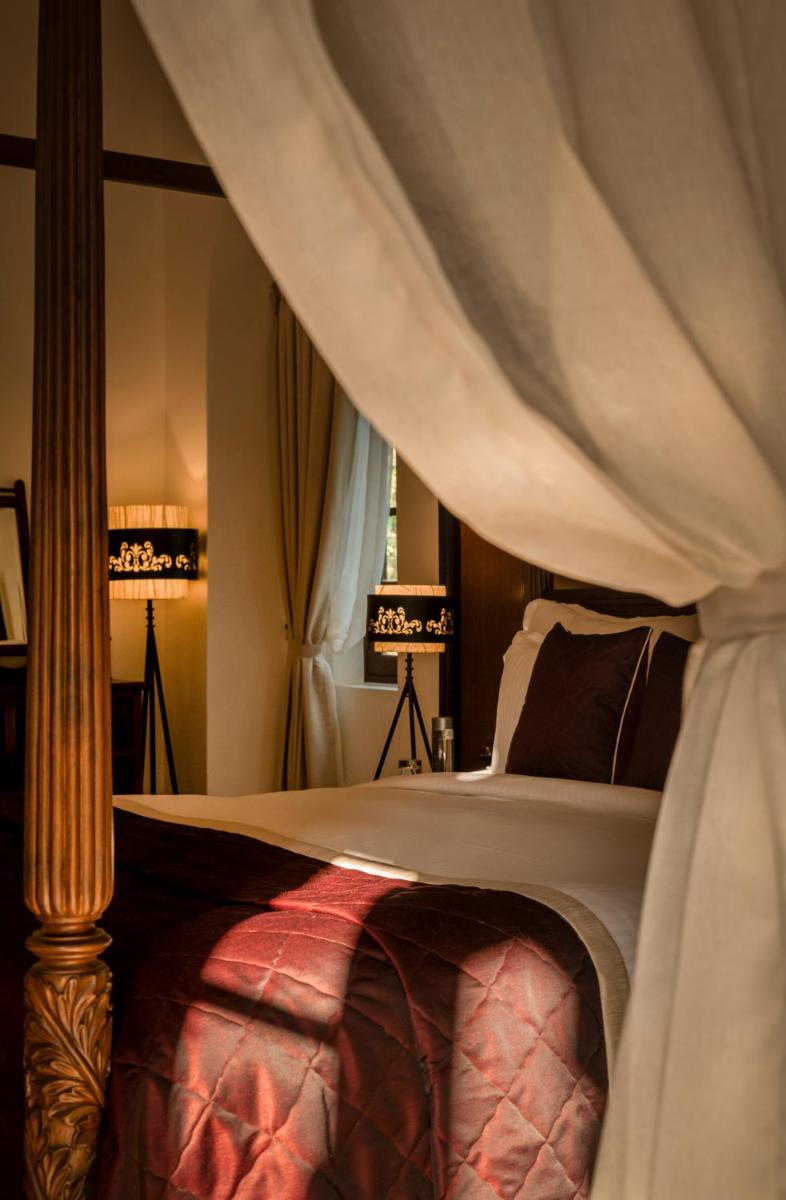 a bedroom with a large bed with a canopy at The Postcard Cuelim, Goa in Cansaulim