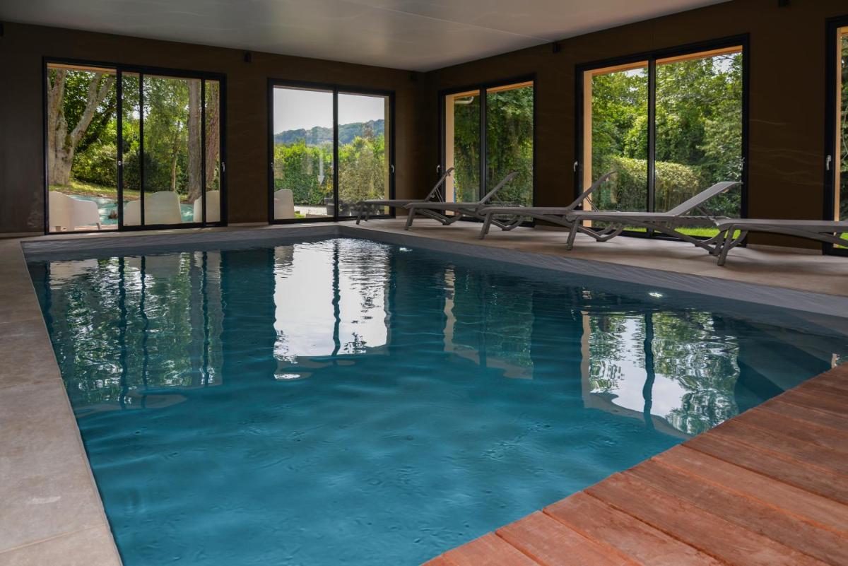 une piscine avec de l'eau bleue dans une maison dans l'établissement La Fraîchette-Hôtel & Spa, à Honfleur