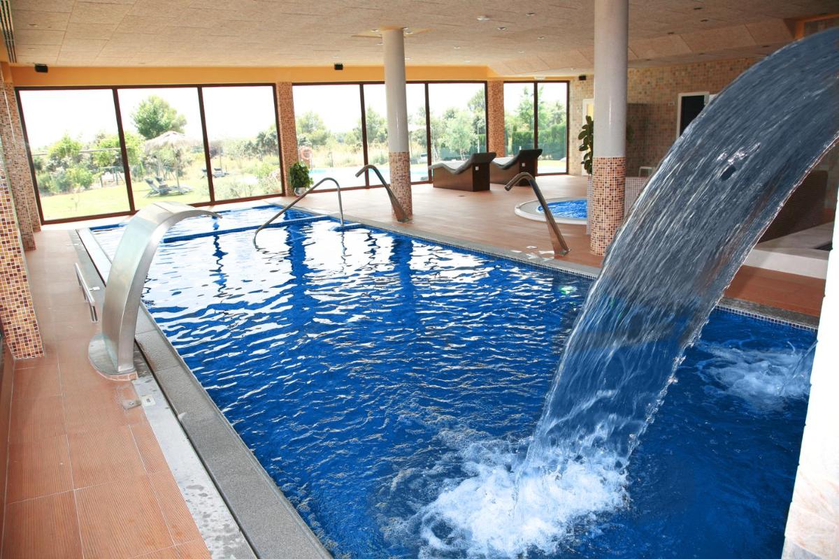 una piscina con cascada en una casa en Hotel Rural Los Nogales, en Pozo Alcón