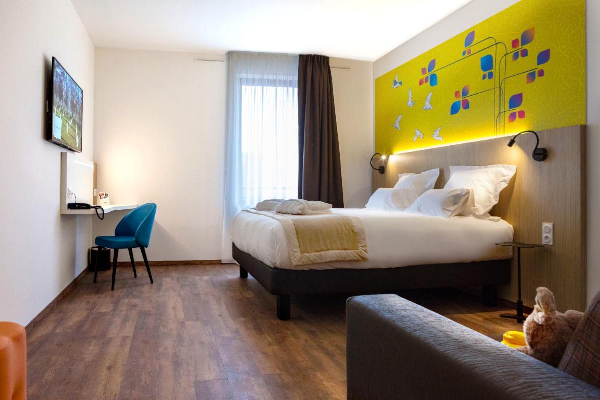 une chambre d'hôtel avec un lit et un mur jaune dans l'établissement Kyriad Prestige Amiens Poulainville - Hotel and Spa, à Poulainville 32 autres photos