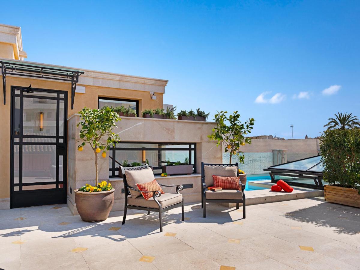 Un patio con dos sillas y una piscina. en Hotel Gloria de Sant Jaume, en Palma de Mallorca