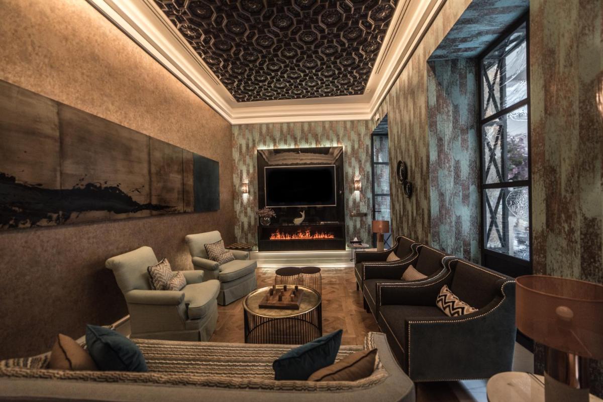 Una sala de estar con sofás y chimenea. en Hotel Casa Palacio María Luisa, en Jerez de la Frontera