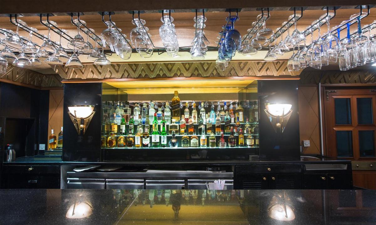 a bar with a lot of bottles of alcohol at The Orchid Hotel Mumbai Vile Parle in Mumbai
