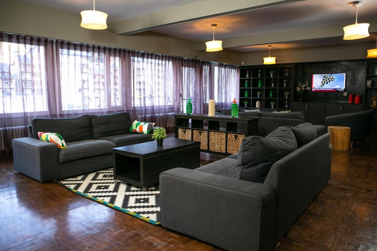 sala de estar amplia con sofás y TV en Hotel Snö Condes del Pallars, en Rialp
