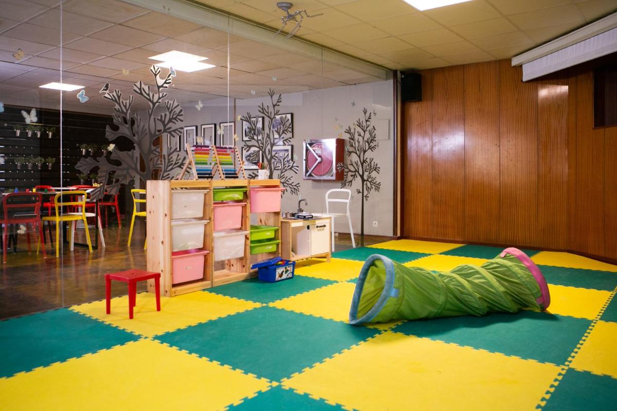 una habitación con un suelo colorido con una bolsa verde. en Hotel Snö Condes del Pallars, en Rialp