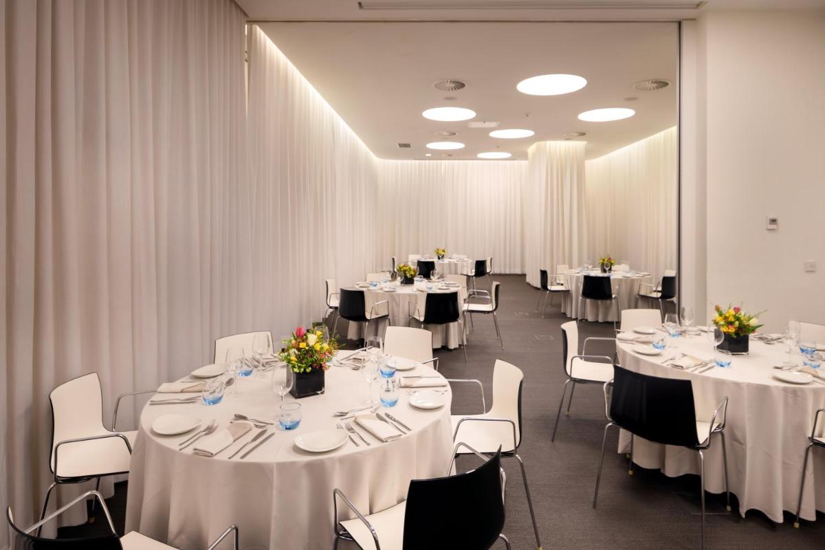 uma sala de conferências com mesas e cadeiras com toalhas de mesa brancas em Inspira Liberdade Boutique Hotel em Lisboa