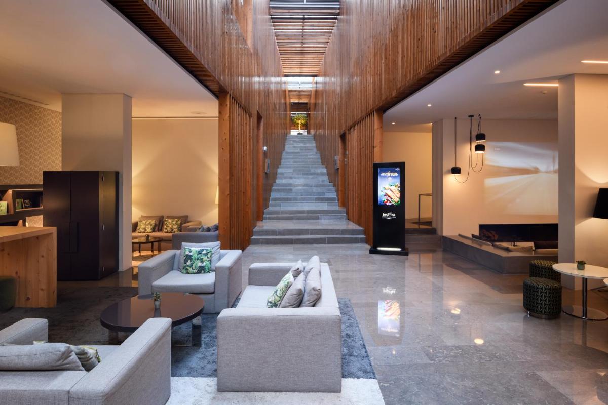 um longo corredor com sofás e uma escada em Inspira Liberdade Boutique Hotel em Lisboa