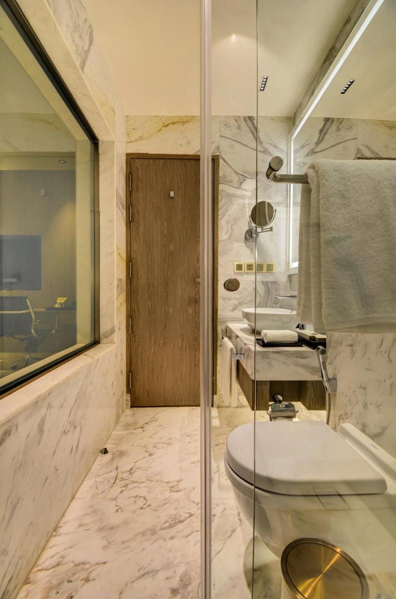 a bathroom with a shower and a toilet and a sink at Vividus in Bengaluru a bathroom with a shower and a toilet and a sink at Vividus in Bengaluru