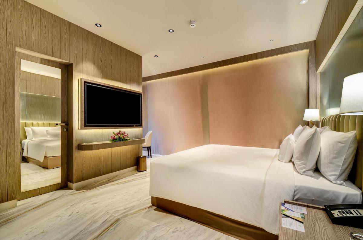 a hotel room with a bed and a television at Vividus in Bengaluru a hotel room with a bed and a television at Vividus in Bengaluru