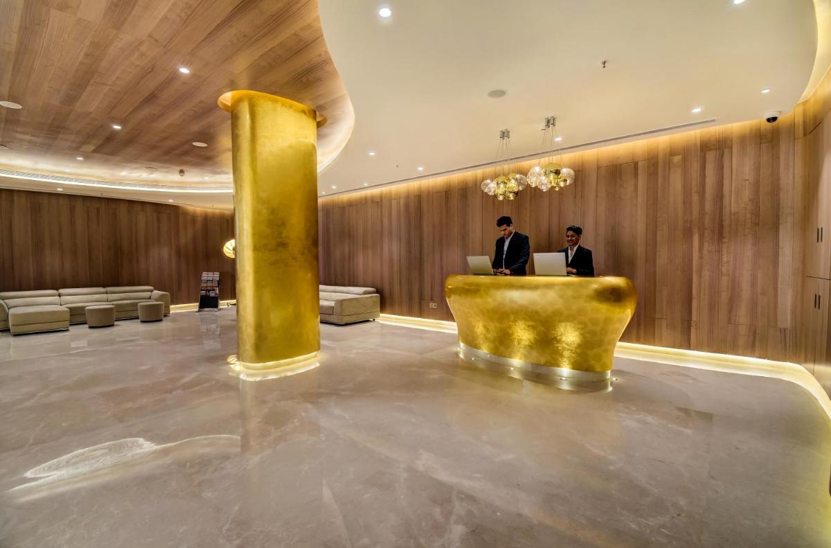 a lobby with two men sitting at a desk with laptops at Vividus in Bengaluru a lobby with two men sitting at a desk with laptops at Vividus in Bengaluru
