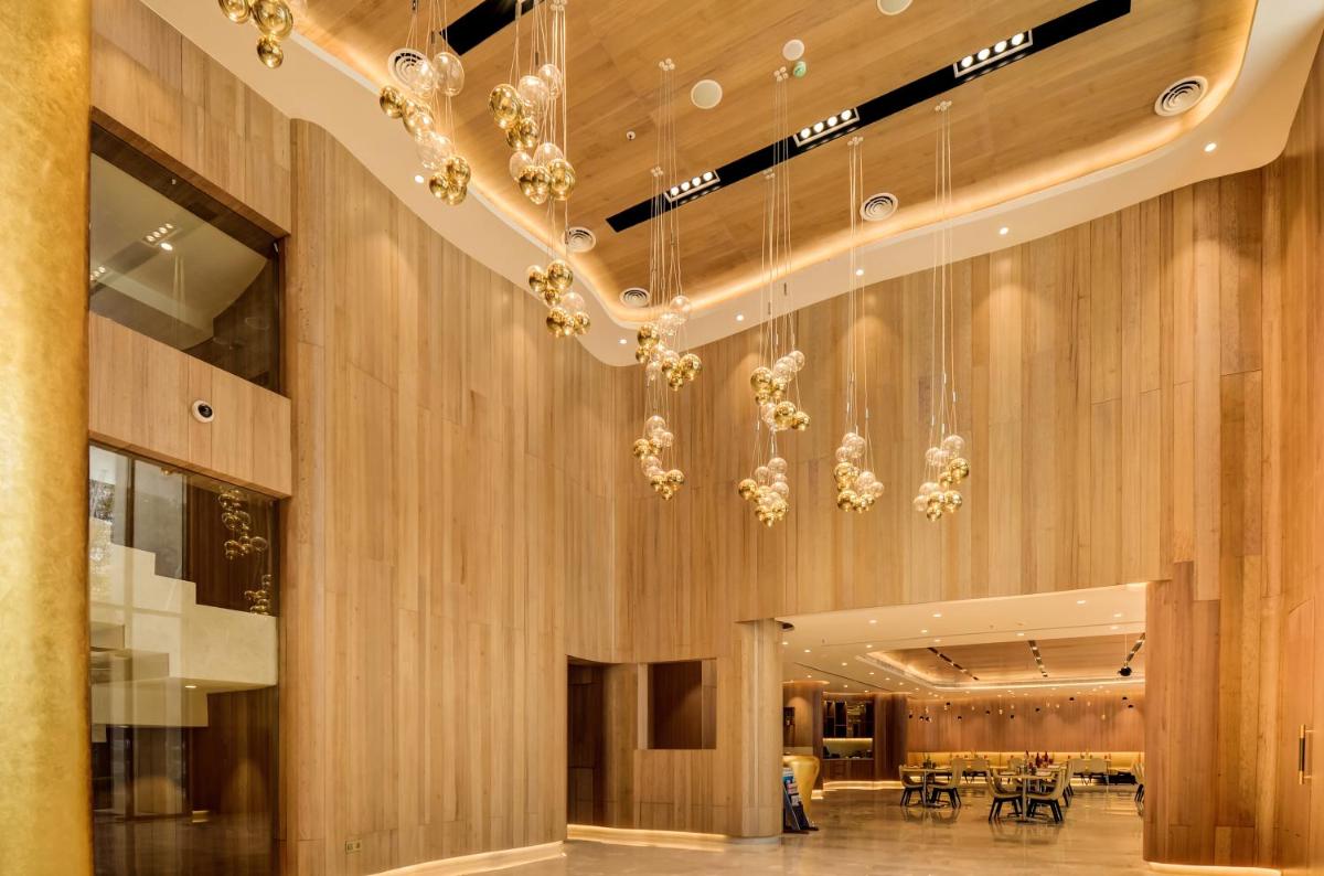 a lobby with a chandelier hanging from the ceiling at Vividus in Bengaluru a lobby with a chandelier hanging from the ceiling at Vividus in Bengaluru