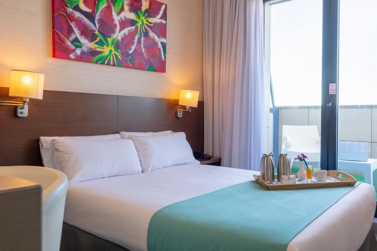 Una habitación de hotel con una cama con una bandeja encima. en Hotel & Spa Real Ciudad De Zaragoza, en Zaragoza