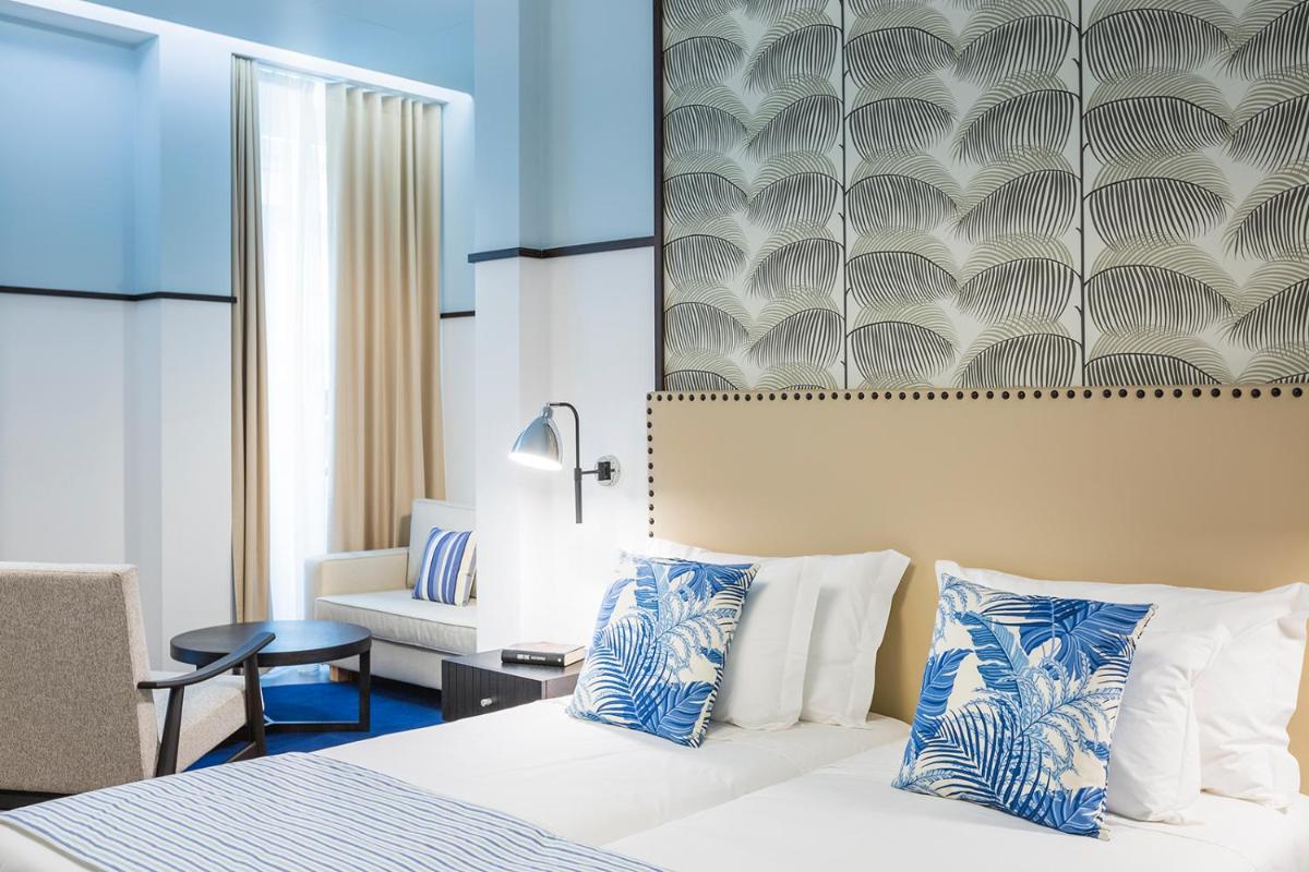 um quarto de hotel com uma cama e uma cadeira em Castanheiro Boutique Hotel no Funchal mais 80 fotografias