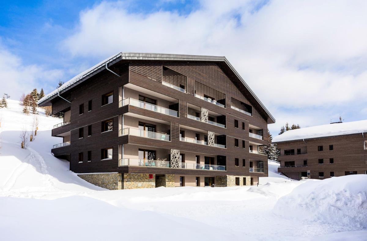 Un bâtiment dans la neige avec de la neige autour de lui dans l'établissement Résidence Club MMV Les Chalets des Cimes, aux Saisies