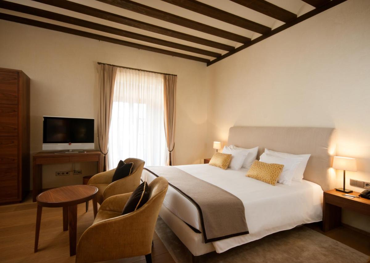 Una habitación de hotel con una cama y una ventana. en Abadia Retuerta LeDomaine, en Sardoncillo